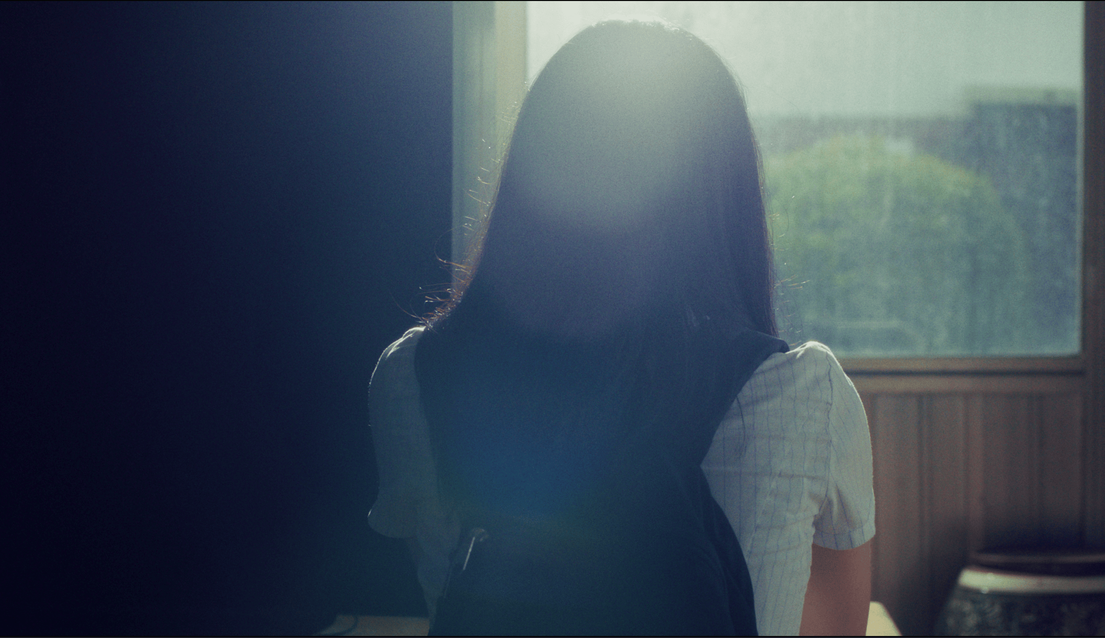 Photo of rows of books in a library with marble busts.